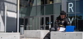 Male Student with Laptop Outside Building