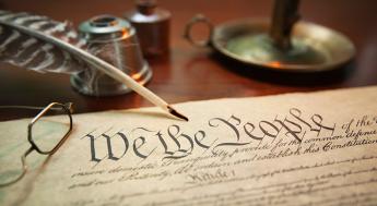 United States Constitution with quill, glasses and candle holder