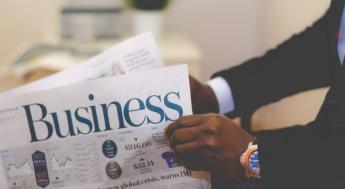 person in suit reading business periodical 