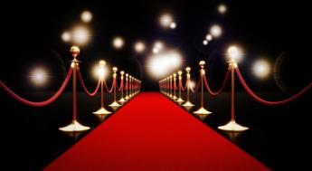 red carpet with crowd control pilars and flashing camera lights