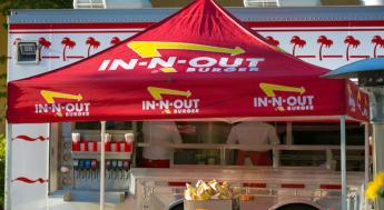 in n out truck with red logo tent in front