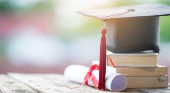 graduation hat with diploma and books