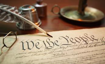 United States Constitution with quill, glasses and candle holder
