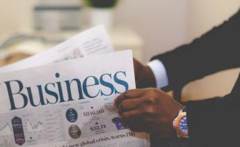person in suit reading business periodical 