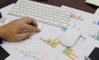 spreadsheets on table under mouse and keyboard