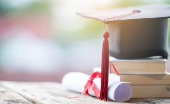graduation hat with diploma and books