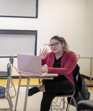 Girl with Glasses Sitting at Class with Laptop