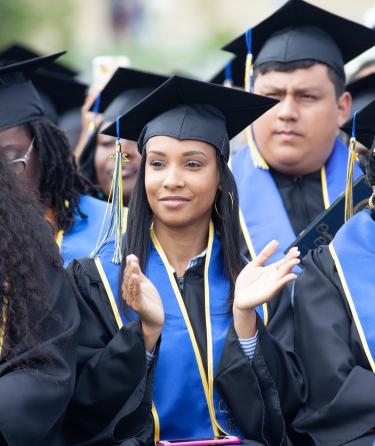 Female Students Clapping at Graduation Event 