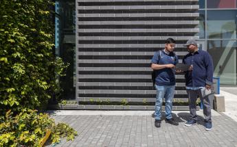 Students Talking Outside with a Laptop