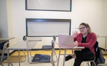 Girl with Glasses Sitting at Class with Laptop