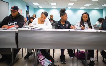 Four Students in Classroom Taking Notes