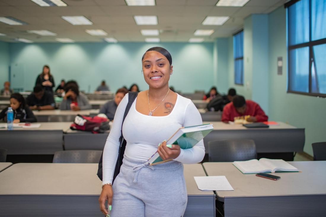 Girl Smilling Carrying Notebooks