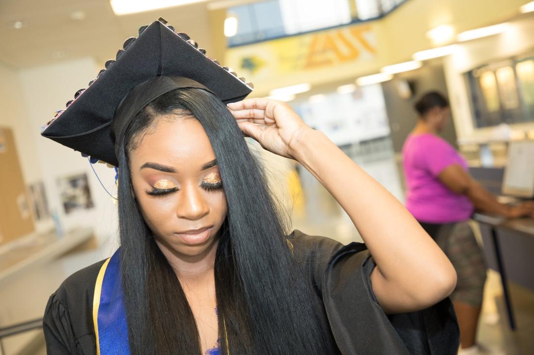 Student Adjusting her Graduation Hat