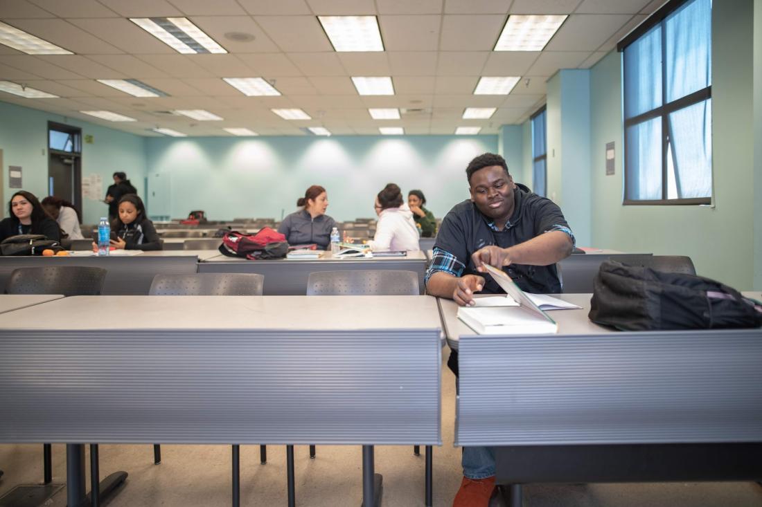 Student at Desk in Front of Classroom