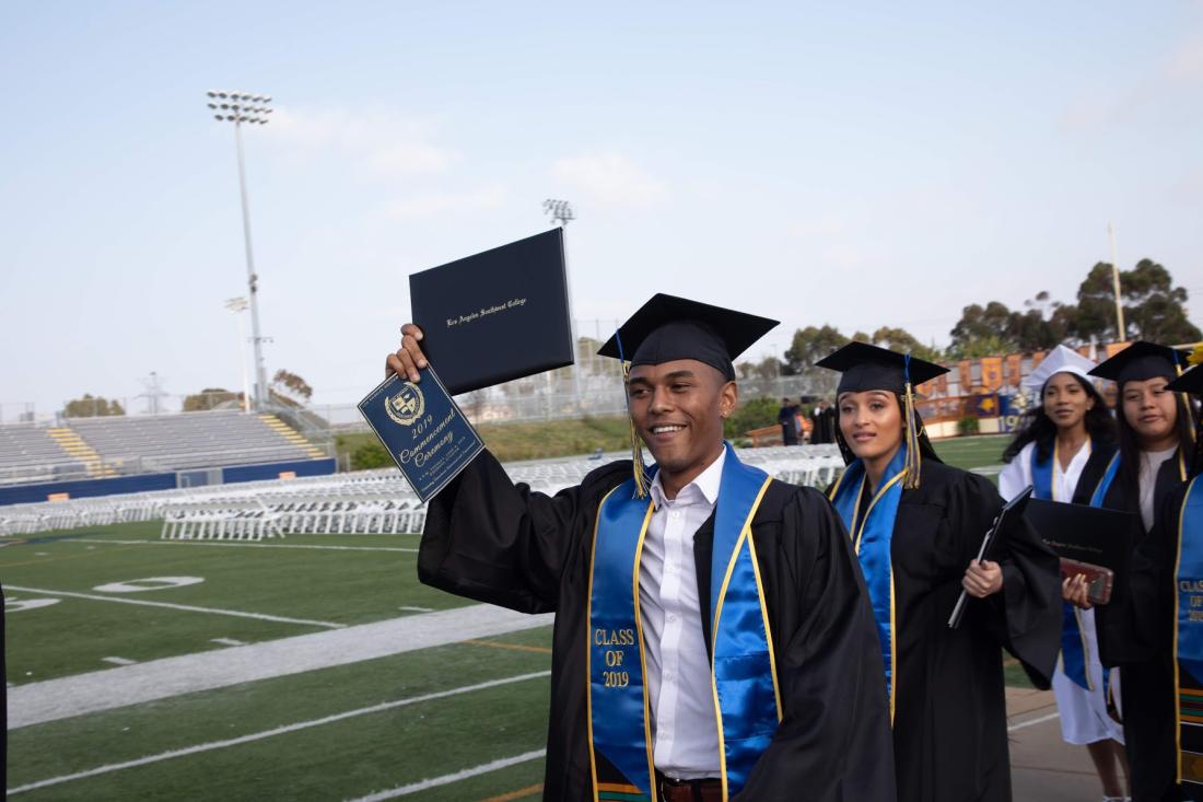 Male Student Rising his Diploma