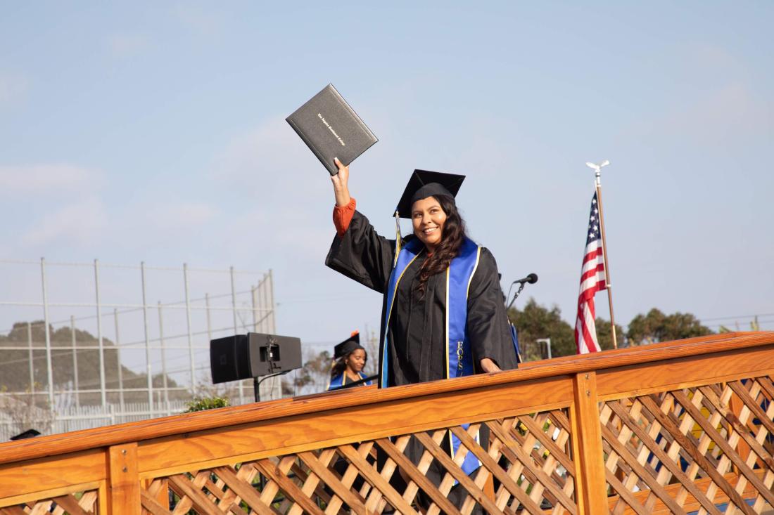 Graduate Woman Raising her Diploma